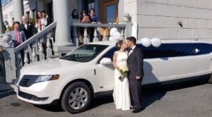 couple kissing in front of a limousine in Hollistion MA